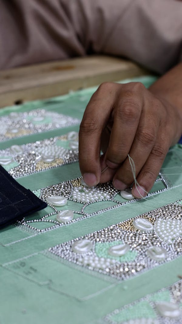 Artisan hand embroidering intricate designs on fabric