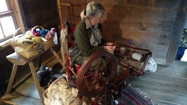 Village woman spinning wool thread on a traditional spinning wheel