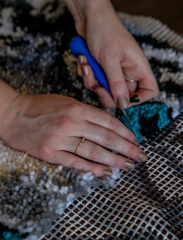 Close up hands doing intricate needlework on fabric